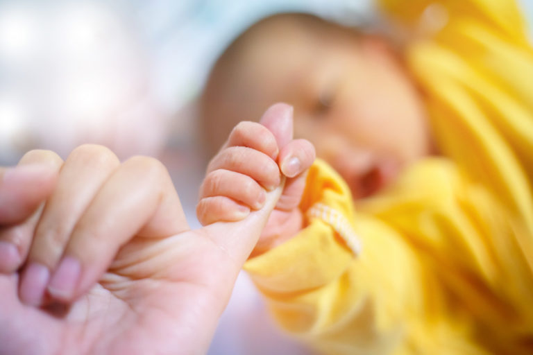 Newborn baby touching his mother hand, Baby holding finger of hi